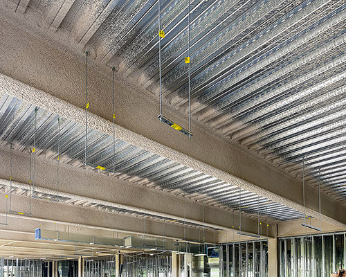 Uniform layer of Spray Applied fireproofing on a beam on construction site